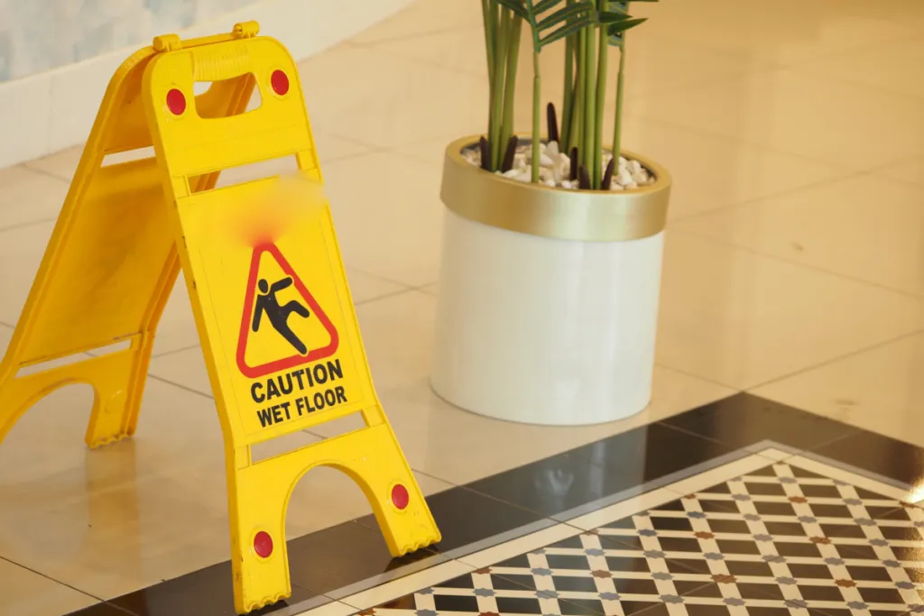 Wet floor warning sign on tiled flooring illustrating slip-and-fall hazards in apartment buildings
