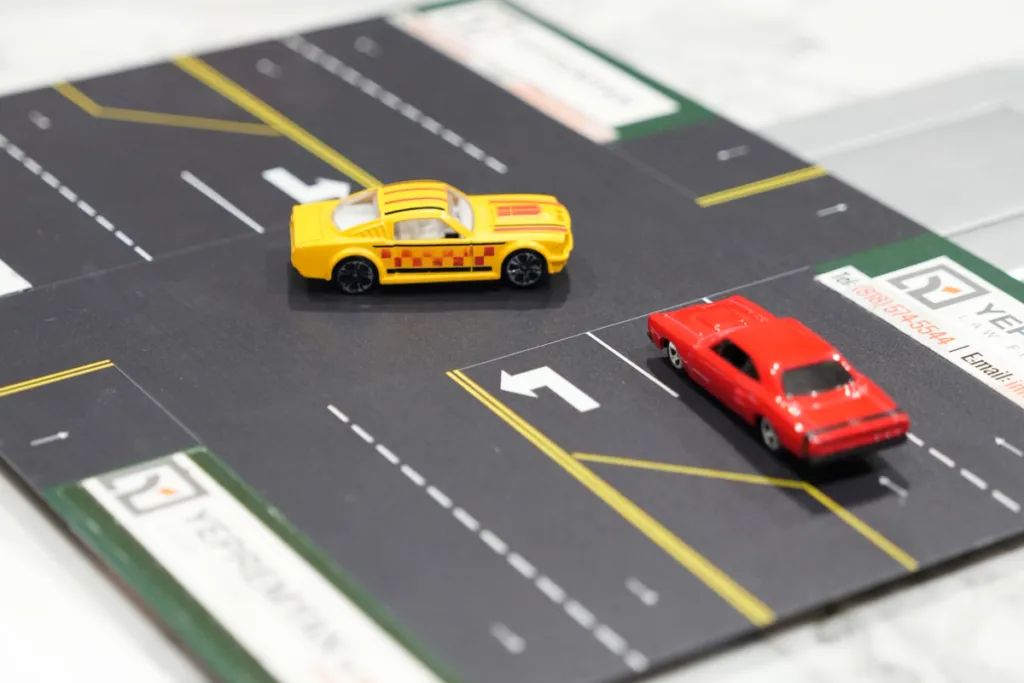 Two miniature cars on a road diagram illustrating a traffic scenario